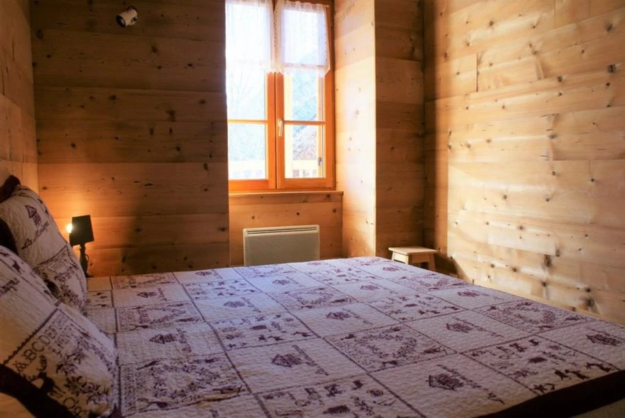 Chalet Milliat - slaapkamer met raam en 2-persoosnbed