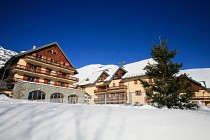 Residence Les Sybelles - chalets met sneeuw en boom