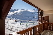 Le Cheval Blanc - balkon met uitzicht op de piste