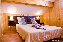 Slaapkamer tweepersoonsbed in Les Chalets des Ecourts 